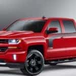Red and black 2016 Chevy Silverado truck parked in a grey room