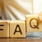 Brown blocks with black letters that spell out "FAQ" being placed on a brown table