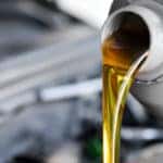 Vehicle oil pouring out of a grey bottle