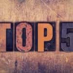Words "Top 5" written in dirty vintage letterpress type on an aged wooden background