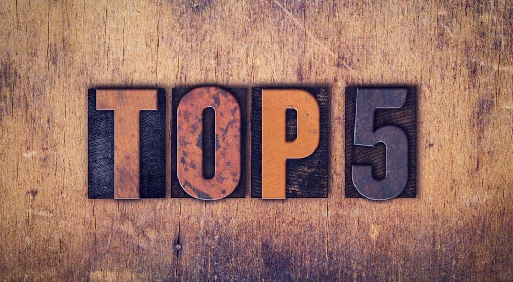 Words "Top 5" written in dirty vintage letterpress type on an aged wooden background