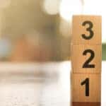 Three blocks numbered from one to three stacked on top of one another on a brown table