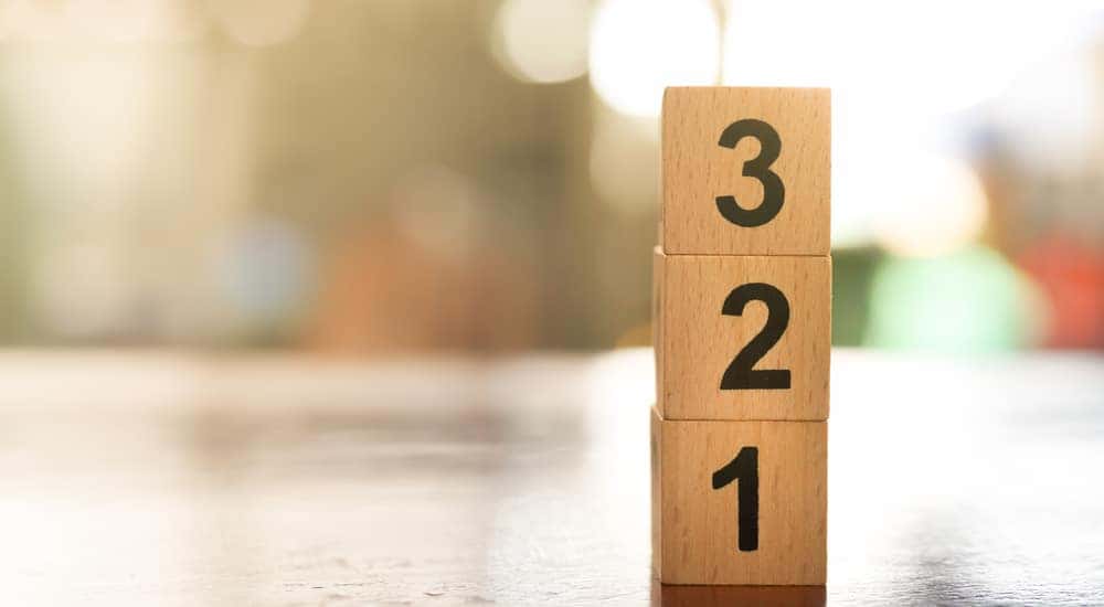 Three blocks numbered from one to three stacked on top of one another on a brown table