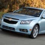 Light blue 2016 Chevrolet Cruze sedan driving down a paved road