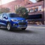 Blue 2017 Chevrolet Trax SUV parked in front of brick storefronts