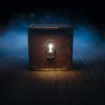 Brown box with a large key hole sitting in front of blue smoke