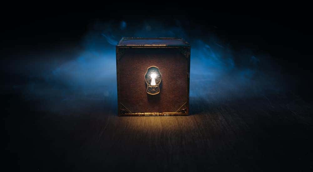 Brown box with a large key hole sitting in front of blue smoke