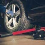 Mechanic in a blue jumpsuit working a tire rotation
