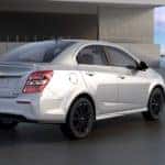 Silver 2017 Chevrolet Sonic parked by a waterside building