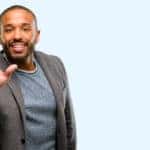 Man in a grey blazer leaning forward with five fingers up