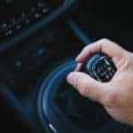 Hand holding onto the gear shift in a vehicle