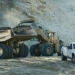 White 2017 Silverado 3500HD pickup truck parked in front of construction vehicles and a tall pile of sand