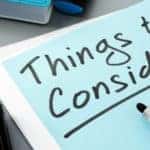 Black marker sitting on top of a blue paper with the words "Things to Consider" written on it in black ink