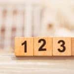 Wooden blocks with black numbers one them counting from one to four