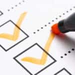 White paper with black boxes with orange check marks in them followed by black dotted lines