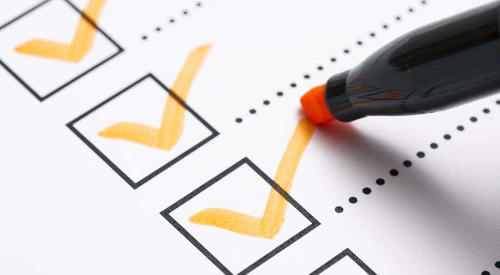 White paper with black boxes with orange check marks in them followed by black dotted lines