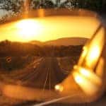 Long road and a sunset in the driver's side mirror of a vehicle