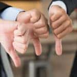 Three businessmen giving thumbs down