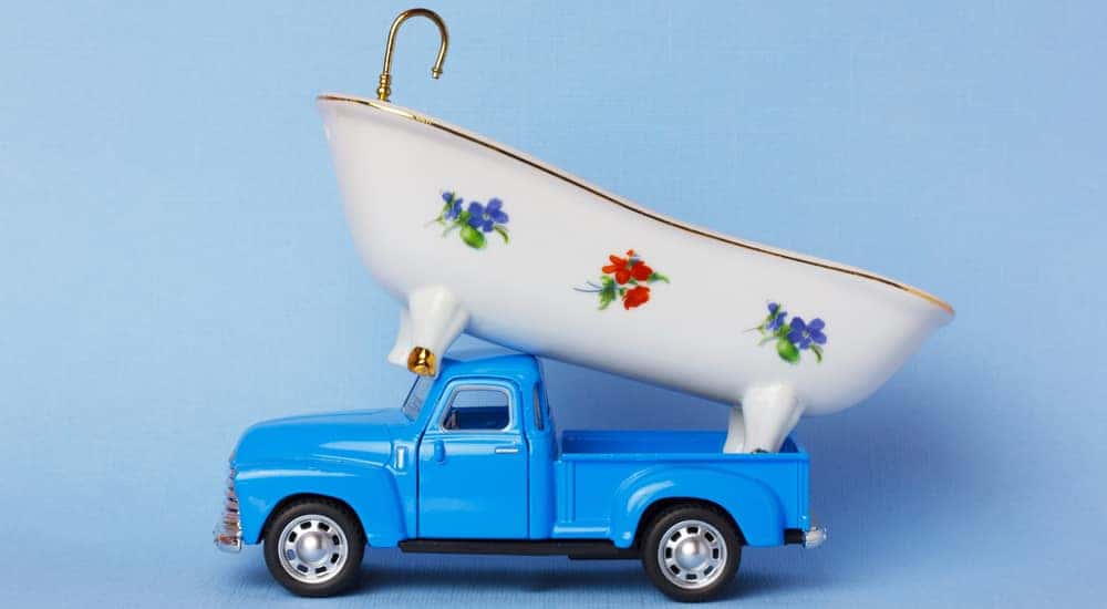 Blue toy pickup truck with a white toy tub on top of it