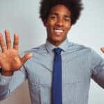 Man in a blue button-up shirt and blue tie holding up all ten of his fingers