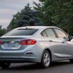 Silver 2017 Chevrolet Cruze sedan parked on a paved pathway next to grass and trees