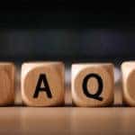 Four brown blocks with black letters on them spelling out "FAQS"