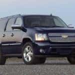 Black 2009 Chevrolet Suburban full-size SUV parked in front of a mountain scenery
