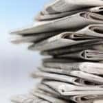 Stack of newspapers with a light blue and white background