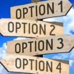 Four brown signs attached on top of one another, pointing in different directions with numbered options on them
