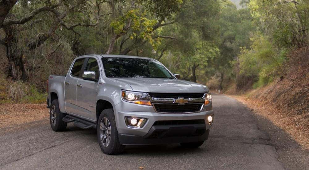 Silver 2018 Chevrolet Colorado parked diagonally under trees on a paved road