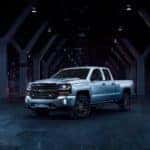 Silver 2018 Chevrolet Silverado Redline edition pickup truck in an all black room