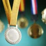 Award medals hanging in front of a green wall
