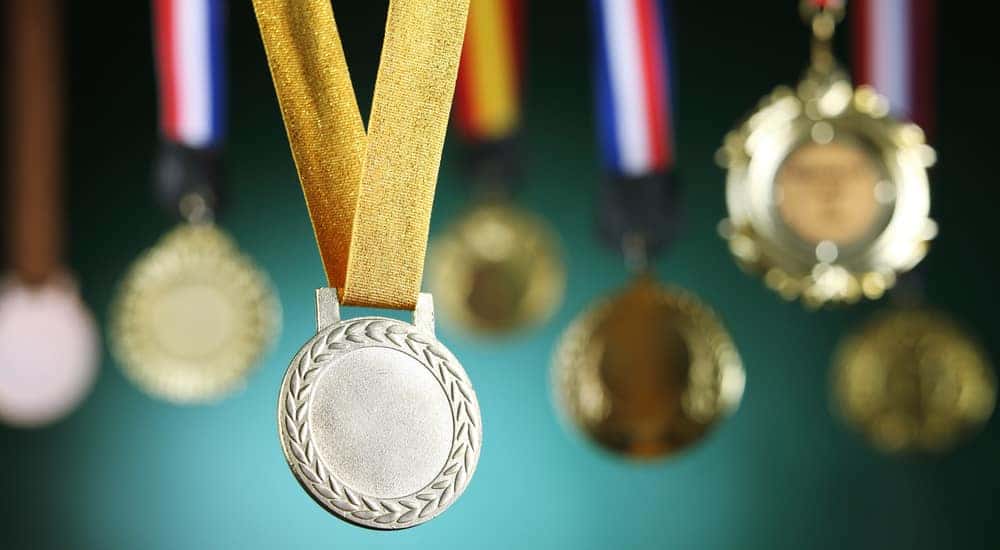 Award medals hanging in front of a green wall