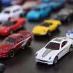 Multiple colors of toy cars sitting on a table