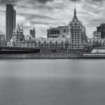 Black and white image of the Hudson River in front of tall, downtown Albany buildings