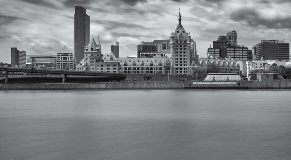 Black and white image of the Hudson River in front of tall, downtown Albany buildings