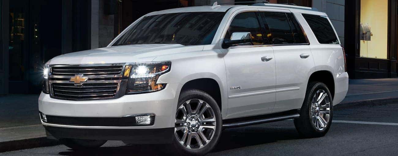 A white 2020 Chevy Tahoe is parked on a dark city street near Albany, NY.