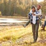 A family is smiling while hiking on an Albany, NY trail next to a river.
