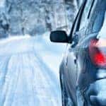 A car is driving on a snow covered road in Albany, NY.