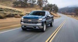 A dark blue 2020 Chevy Silverado is driving past fog near Albany, NY.