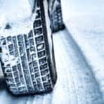 Close up of tires driving through snow on a road