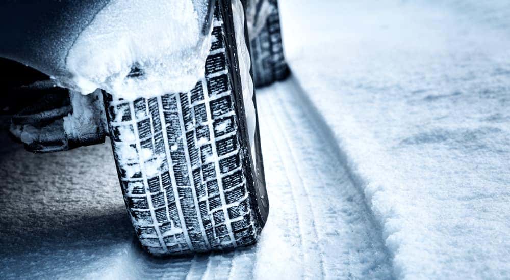 Close up of tires driving through snow on a road