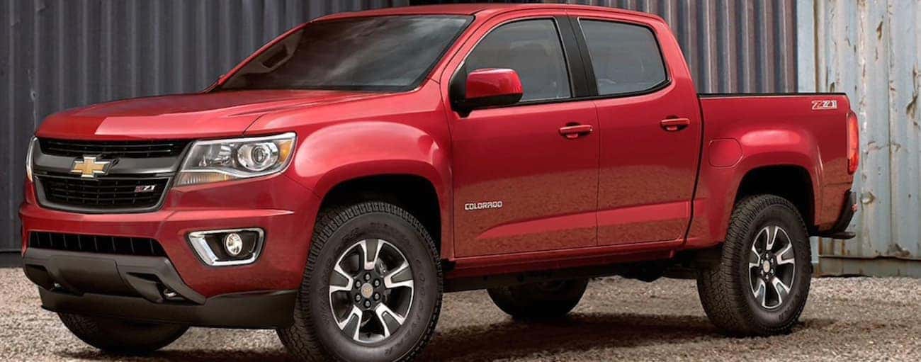 A red 2020 Chevy Colorado is parked on a gravel parking lot.
