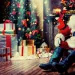 Santa is sitting in front of a tree with presents at an Albany, NY home.
