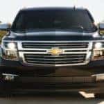 A close up of the front end of a black 2020 Chevy Suburban is shown.