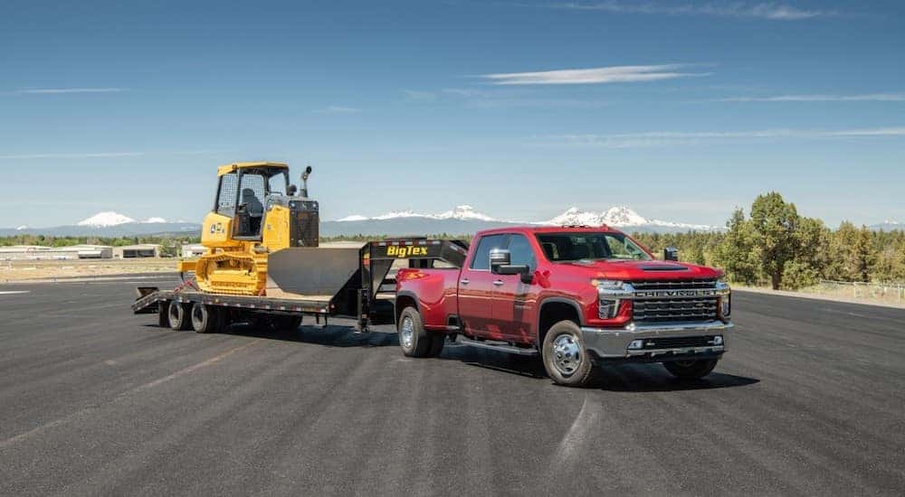 Red 2020 Chevrolet Silverado 3500HD towing construction equipment