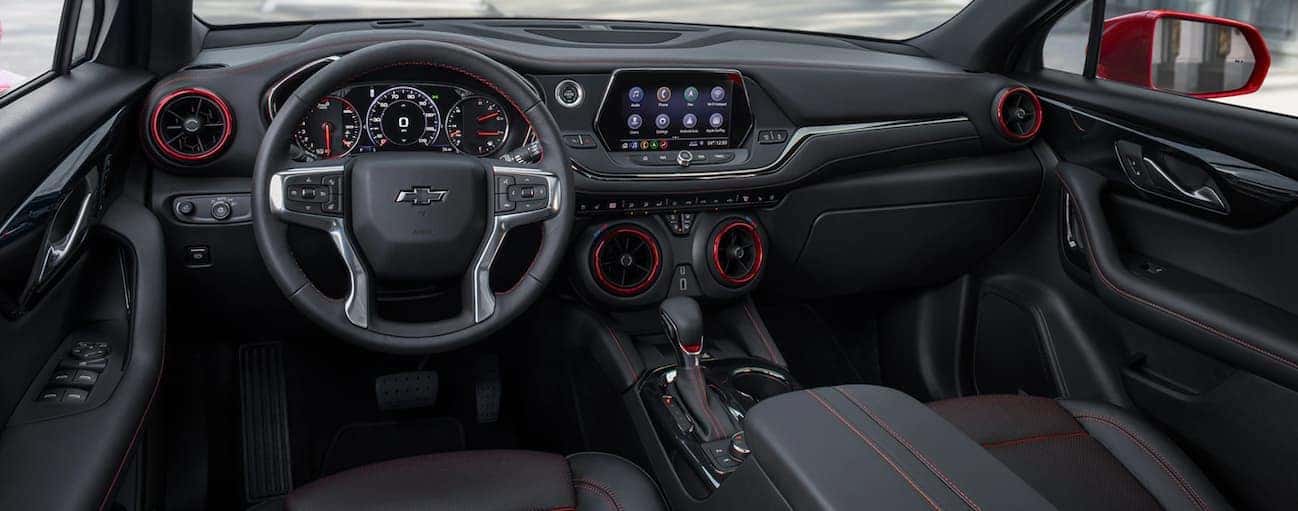 The front black and red leather interior of a 2020 Chevy Blazer is shown with an infotainment system.