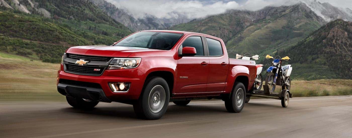 A red 2020 Chevy Colorado is towing a trailer with dirt bikes.