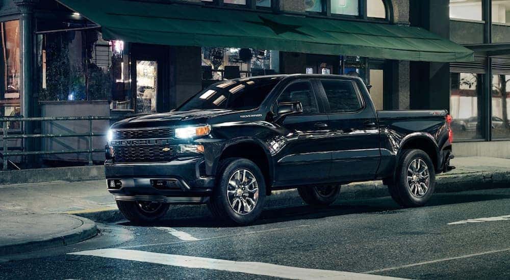 A black 2020 Chevy Silverado 1500 is parked in front of a store front after leaving a Chevy Dealership near Clifton Park, NY.