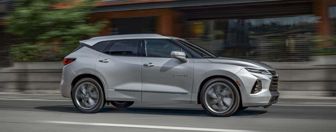A silver 2020 Chevy Blazer is driving past brick buildings near Albany, NY.